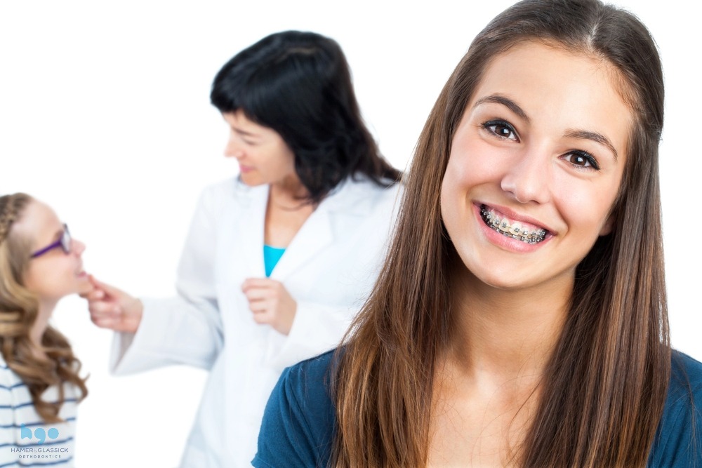 Teen girl with braces at an orthodontist's office, happily learning how to fix overbite in Charlottesville and Crozet, VA with traditional treatment.