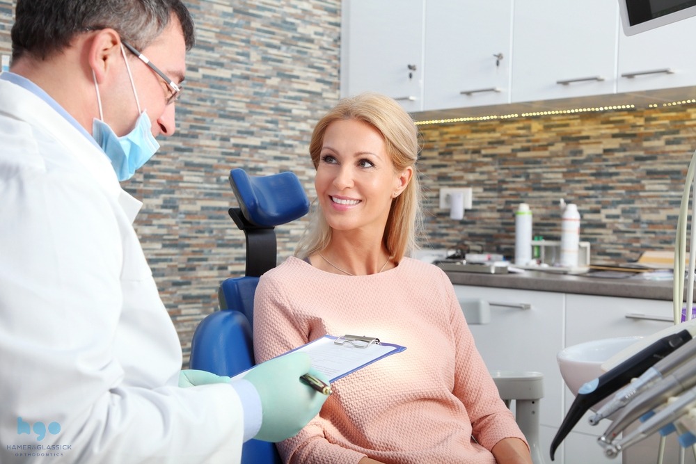 Orthodontist in Charlottesville discussing treatment options with a patient in a modern dental office, emphasizing personalized care and comfort for TMJ relief.